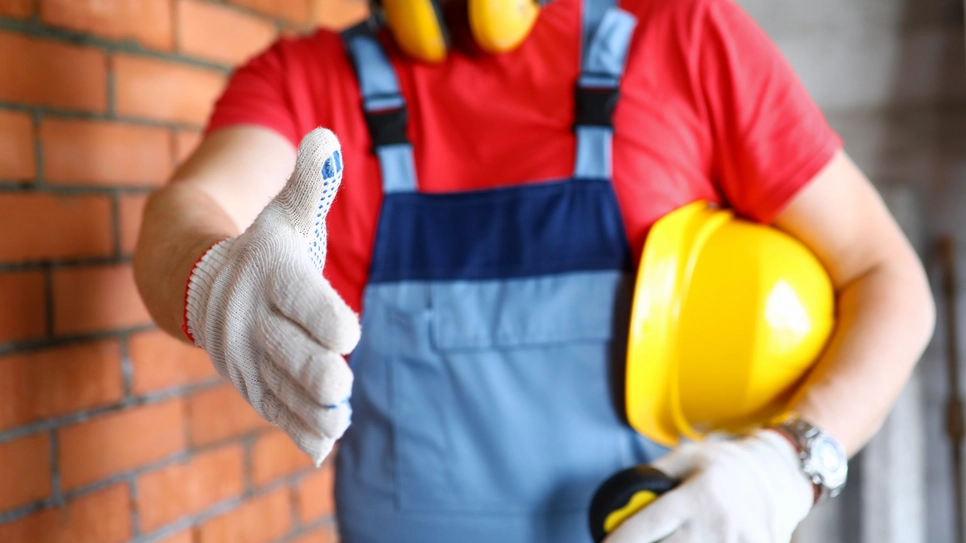 Un muncitor în construcții își oferă mâna pentru o ofertă înainte.