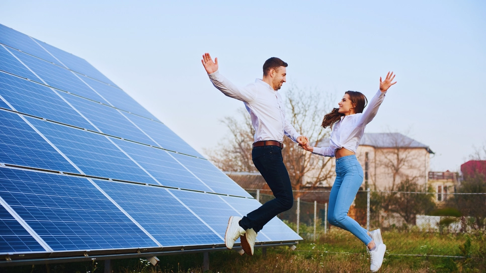 tânăr cuplu fericit în fața panourilor solare