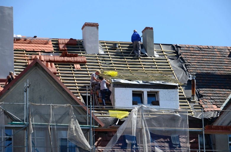 Lucrătorii de acoperișuri care înlocuiesc un acoperiș.