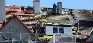 Lucrătorii de acoperișuri care înlocuiesc un acoperiș.