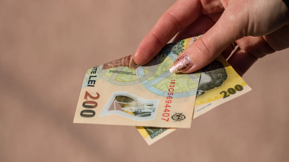 o mână de femeie plătește cu bancnote