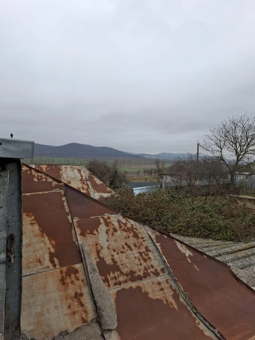 Acoperiș metalic ruginit cu vedere spre peisaj rural (41547)