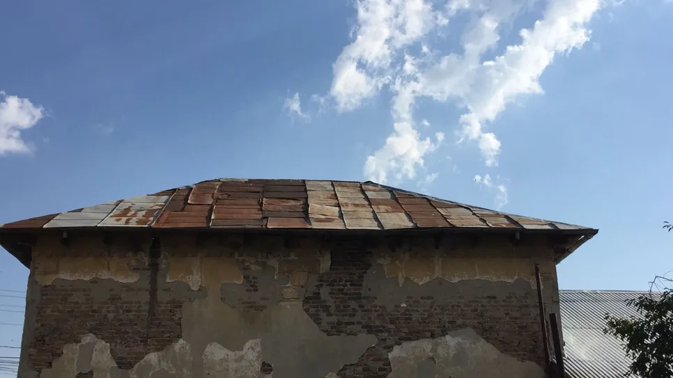 Rusty roof under blue sky (3795) Aged metal roof with rust damage under a clear blue sky, showcasing wear and tear.