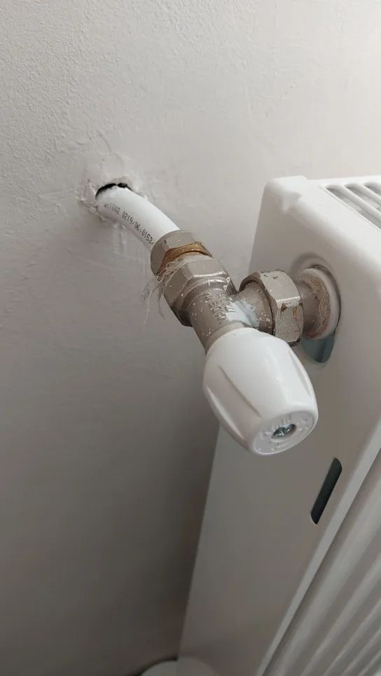Leaky radiator pipe connection (13167) Leaking radiator pipe connection causing moisture damage on the wall, visible with rust on the valve.