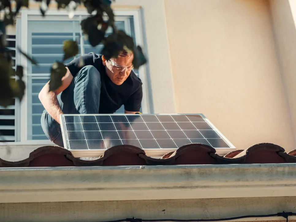 Panou solar acoperiș Un meșter instalează panouri solare pe acoperiș.