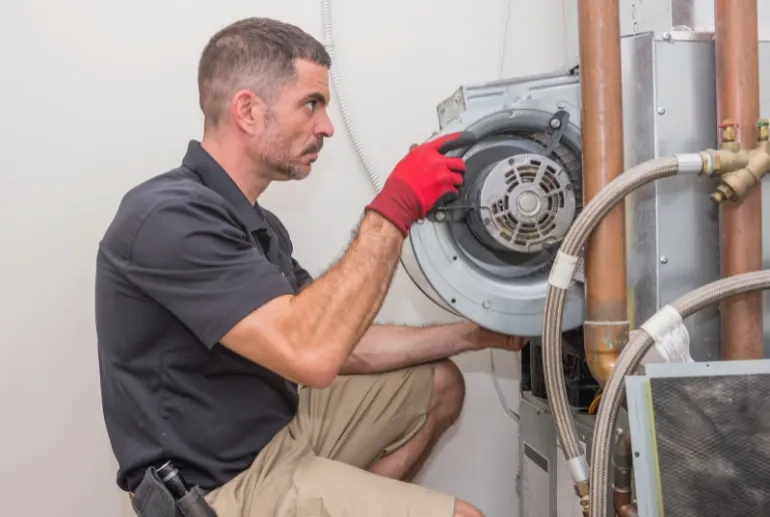 Repararea pompelor de căldură Un tehnician repară o pompă de căldură.